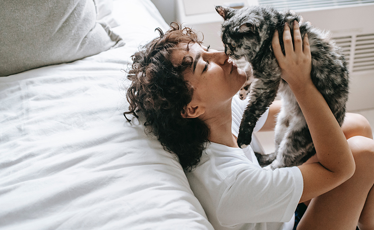 1.-woman-caressing-cat-in-hands-chilling-in-bedroom